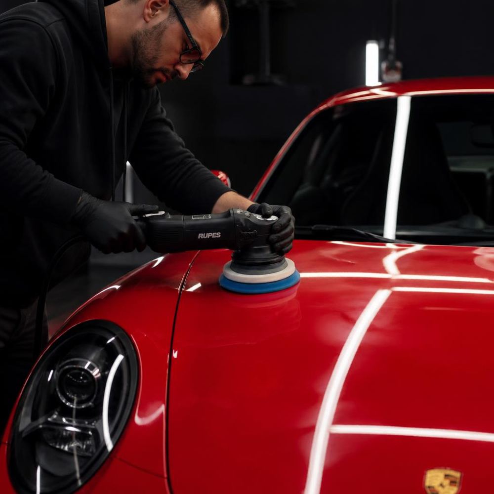 Corrección de pintura con pulidora en un vehículo rojo